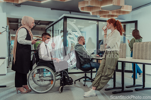 Image of Young group of business people brainstorming together in a startup space, discussing business projects, investments, and solving challenges.