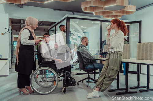 Image of Young group of business people brainstorming together in a startup space, discussing business projects, investments, and solving challenges.