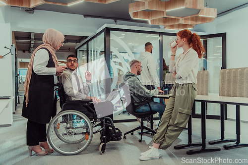 Image of Young group of business people brainstorming together in a startup space, discussing business projects, investments, and solving challenges.