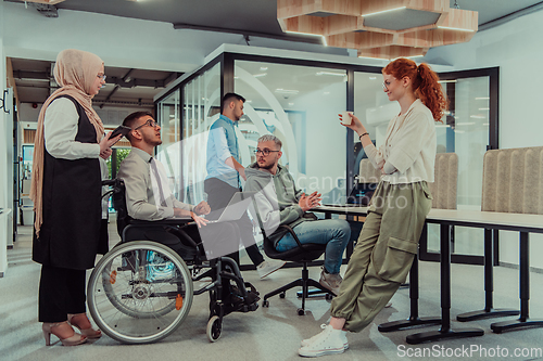 Image of Young group of business people brainstorming together in a startup space, discussing business projects, investments, and solving challenges.