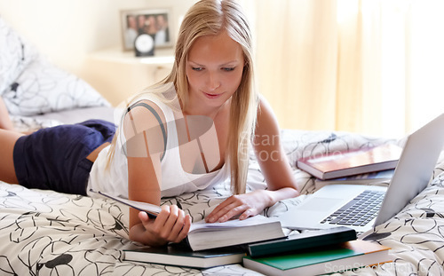 Image of Books, laptop and female student on a bed for learning, research or college homework assignment. Education, university and learner online in bedroom studying, reading or check exam schedule at home