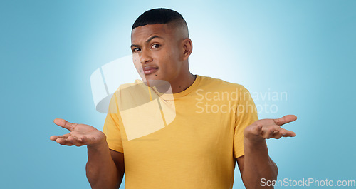 Image of Confused, shrug and portrait of man in studio with why hands on blue background space. Doubt, face and model with dont know emoji for choice, decision or palm scale, questions or asking body language