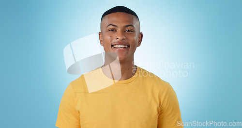 Image of Portrait, young man and smile in studio with confidence, good mood or casual fashion isolated on blue background. Happy gen z model with cheerful personality, pride and mockup space in Puerto Rico