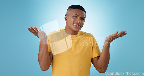 Image of Confused, shrug and man portrait in studio with why hands on blue background space. Doubt, face and model with dont know emoji for choice, decision or palm scale, questions or asking body language