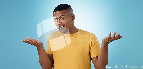 Image of Confused, portrait and man in studio shrug with emoji hands or asking body language on blue background. Why, face and male model with palm scale questions, doubt or comparison, balance or dont know