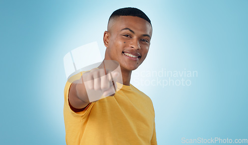 Image of Man, portrait and pointing to you in studio for choice, vote for winner and decision to volunteer on blue background. Happy model show finger for recruitment, hiring emoji and invitation to join us