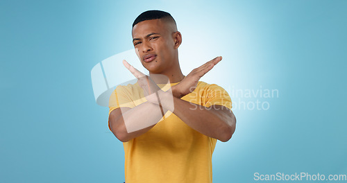 Image of Man, cross and hands for no, portrait or studio with frustrated face for choice by blue background. Person, sign and icon for stop, warning and attention with block emoji, decline or annoyed for fail