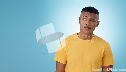 Image of Thinking, confused or problem solving and a man on a blue background in studio with a question on mockup. Doubt, idea or why with a young person on space for planning or brainstorming a solution
