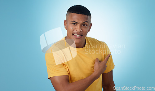 Image of Pointing, question and portrait of man in a studio with mockup for marketing, advertising or promotion. Confused, thinking and young male person with a show hand gesture isolated by blue background.