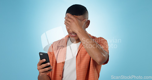 Image of Man, phone and shock for bad news in studio for negative text message, disappointment or loss. Male person, mobile and connection or social media for unhappy discussion, blue background as mockup