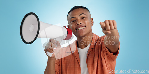 Image of Man, megaphone and choice or pointing you for announcement, broadcast and vote or news on blue background. Portrait of person for join us, attention and voice with sale, bonus or winning in studio