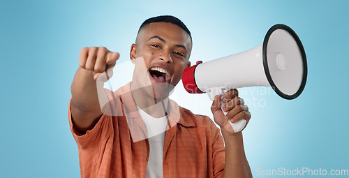 Image of Man, megaphone and winner or pointing you for announcement, broadcast and choice or news on blue background. Portrait of person for join us, attention and voice with sale, bonus or winning in studio