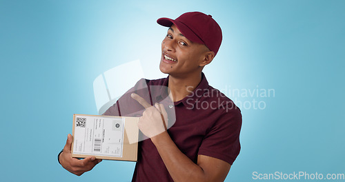 Image of Portrait, happy man and courier for pointing in studio with mock up for announcement on blue background. Cape Town, male model and smile for presentation of alert, promotion or notification in space