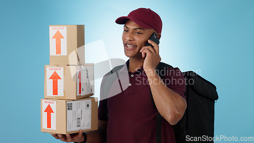 Image of Delivery man, boxes and phone call for courier communication, e commerce information and update on package. Worker or logistics supplier mobile chat for customer service on a blue, studio background