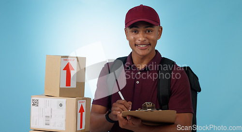Image of Delivery man, boxes and checklist for courier service, distribution and writing invoice on a blue background. Portrait of logistics worker with package, receipt and clipboard or paperwork in studio