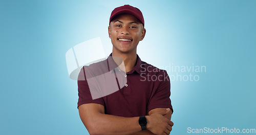 Image of Delivery man, arms crossed or portrait for distribution or mockup space on blue background. Professional, retail supply chain or happy logistics worker for shipping or courier service in studio