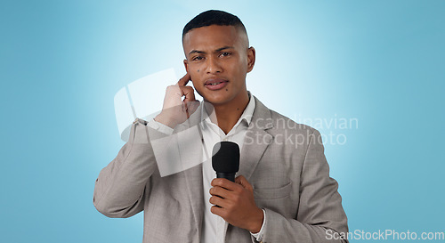Image of Portrait, man and reporter with mic on blue background for mock up in studio in Cape Town. Male journalist, model and listening for breaking news, update or announcement for broadcast in live stream