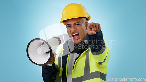 Image of Construction worker, builder or angry man with megaphone in studio for renovation or development. Speaking, pointing or male engineer shouting in building project or communication on blue background