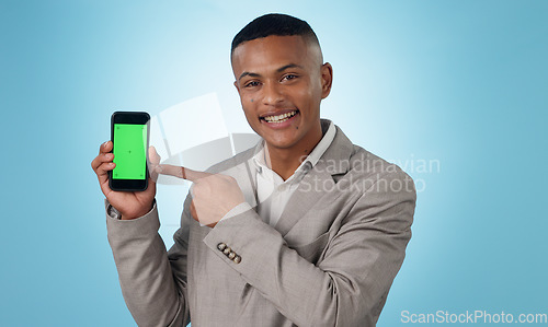 Image of Professional man, phone green screen and pointing to presentation, sign up or website or trading software in studio. Portrait of business trader on mobile mockup, tracking markers and blue background