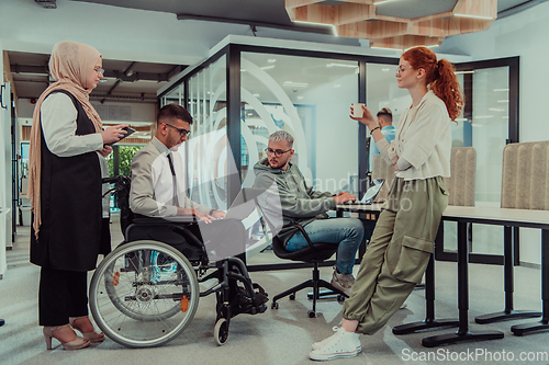 Image of Young group of business people brainstorming together in a startup space, discussing business projects, investments, and solving challenges.