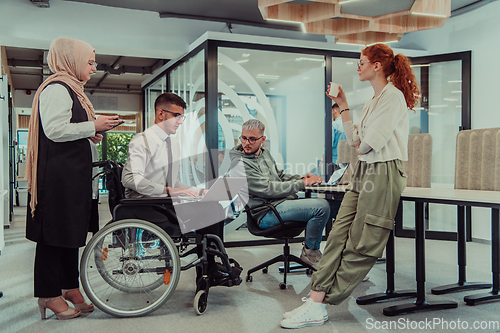 Image of Young group of business people brainstorming together in a startup space, discussing business projects, investments, and solving challenges.