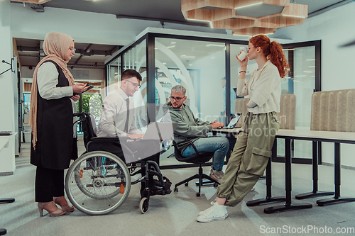 Image of Young group of business people brainstorming together in a startup space, discussing business projects, investments, and solving challenges.