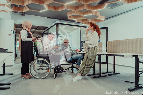 Image of Young group of business people brainstorming together in a startup space, discussing business projects, investments, and solving challenges.