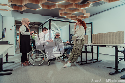 Image of Young group of business people brainstorming together in a startup space, discussing business projects, investments, and solving challenges.