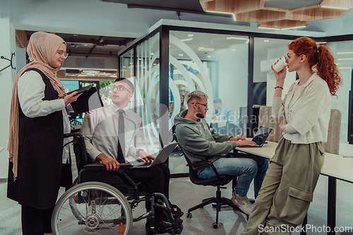 Image of Young group of business people brainstorming together in a startup space, discussing business projects, investments, and solving challenges.