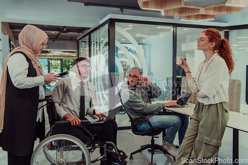 Image of Young group of business people brainstorming together in a startup space, discussing business projects, investments, and solving challenges.