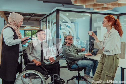 Image of Young group of business people brainstorming together in a startup space, discussing business projects, investments, and solving challenges.