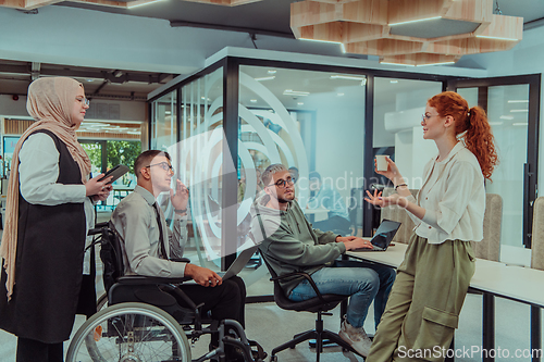 Image of Young group of business people brainstorming together in a startup space, discussing business projects, investments, and solving challenges.