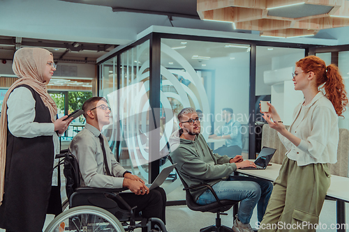 Image of Young group of business people brainstorming together in a startup space, discussing business projects, investments, and solving challenges.