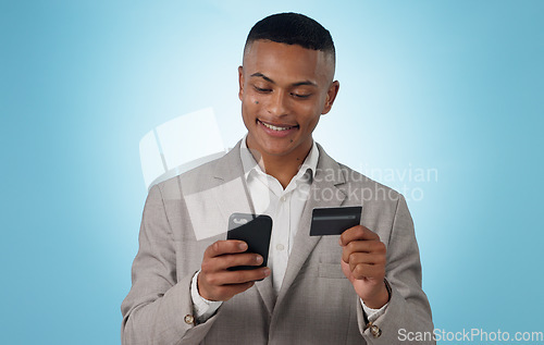 Image of Business man, credit card and phone in studio for ecommerce, financial accounting or banking investment on blue background. Happy worker, mobile and fintech for online shopping, stock trading or deal