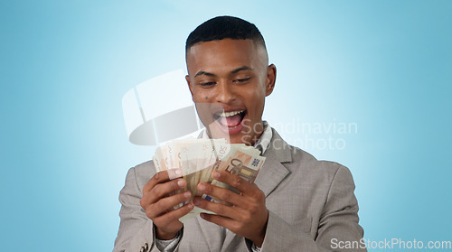 Image of Business man, wow and money for winning, success and lottery prize, bonus or stock market profit in studio. Excited winner or young trader with cashback and surprise for savings on a blue background