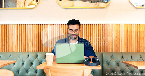 Image of Man in coffee shop, typing on laptop and remote work, reading email and writing blog, article and research in restaurant. Computer, freelancer and editor in cafe, store and technology for internet