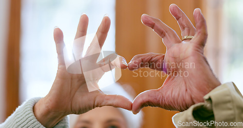 Image of Closeup, home and senior couple with heart hands, support and romance with retirement, relationship and care. Apartment, elderly man and old woman with symbol for love, marriage and romantic with joy