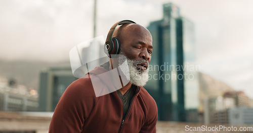 Image of Man, headphones and tired from exercise, city and challenge in outdoor fitness, fatigue and dehydrated. Black mature person, exhausted and workout in retirement, listen and streaming radio or podcast