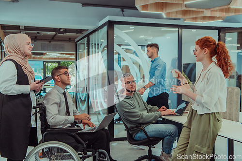 Image of Young group of business people brainstorming together in a startup space, discussing business projects, investments, and solving challenges.