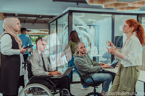 Image of Young group of business people brainstorming together in a startup space, discussing business projects, investments, and solving challenges.