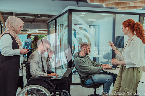 Image of Young group of business people brainstorming together in a startup space, discussing business projects, investments, and solving challenges.