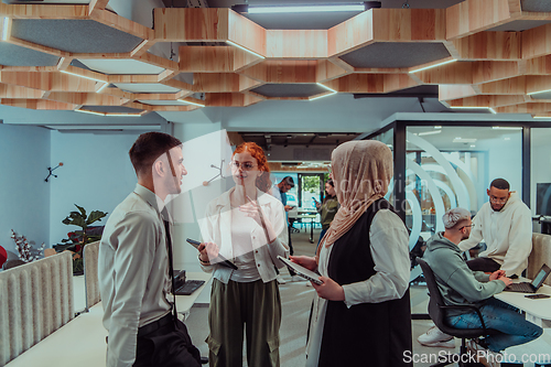 Image of Young group of business people brainstorming together in a startup space, discussing business projects, investments, and solving challenges.