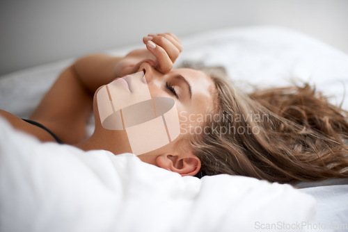 Image of Sleeping, peace and tired woman relax in a bed calm, resting and dreaming in her home or apartment. Fatigue, face female person lying in bedroom for burnout recovery, nap or weekend comfort in house