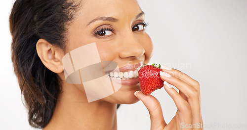 Image of Smile, strawberry and portrait of woman in studio for wellness, nutrition and organic diet. Happy, vitamins and young female person from Mexico eating fruit for health vegan snack by gray background.