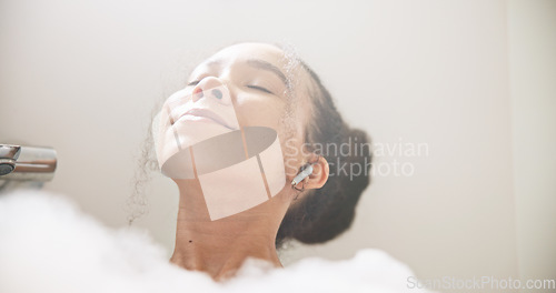 Image of Music, face or happy woman in a bath in hotel cleaning, grooming or body care in soap foam. Relax, earphones or calm lady lying in water in spa, home or bathroom streaming or listening to radio song