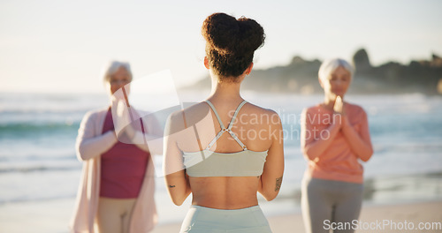 Image of Beach yoga class, people and back of coach teaching exercise, outdoor wellness and relax workout. Trainer, community instructor and yogi group learning pose, training and teacher coaching pilates