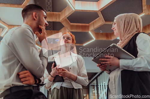 Image of Young group of business people brainstorming together in a startup space, discussing business projects, investments, and solving challenges.