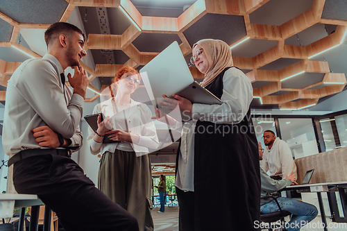 Image of Young group of business people brainstorming together in a startup space, discussing business projects, investments, and solving challenges.