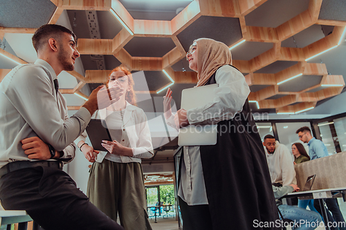 Image of Young group of business people brainstorming together in a startup space, discussing business projects, investments, and solving challenges.