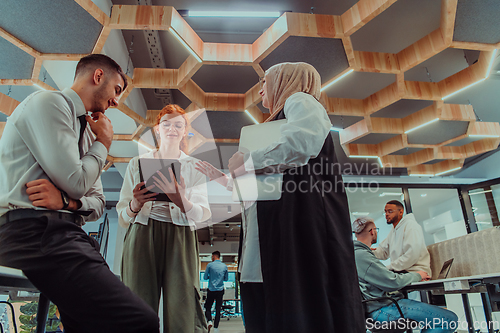 Image of Young group of business people brainstorming together in a startup space, discussing business projects, investments, and solving challenges.